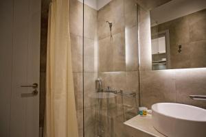 a bathroom with a shower and a sink and a mirror at Phoenix studios in Mikonos