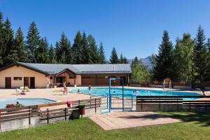 a swimming pool with people playing in it at Vacancéole - Résidence Le Beauregard in La Léchère