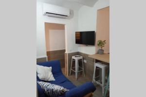 een woonkamer met een blauwe bank en een tafel bij M2 Cool apartment next to metro. 15m to center in Esplugues de Llobregat