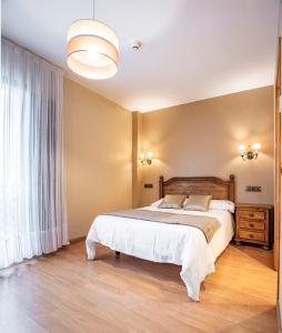 a bedroom with a bed and a large window at Hotel Santa Cruz in Cangas de Onís