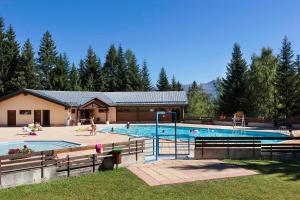 a swimming pool with people playing in it at Vacancéole - Résidence La Duit in La Léchère