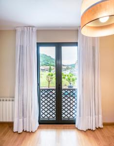 a view through a window of a room with a balcony at Hotel Santa Cruz in Cangas de Onís