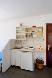 a kitchen with white cabinets and a sink at Margarita Studios in Parikia
