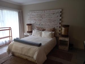 een slaapkamer met een groot bed met een bakstenen muur bij Troas Boutique hotel in Vanderbijlpark