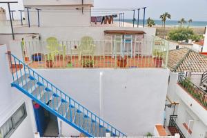 Un balcón con sillas y mesas en un edificio en Habitación Cañaveral Playa Conil I, en Conil de la Frontera