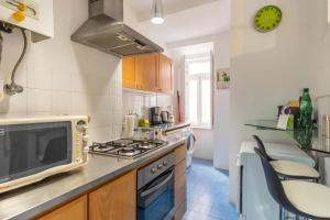 a kitchen with a stove and a microwave at LV Premier Apartments Baixa- CN in Lisbon