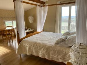a bedroom with a bed and a table and a window at Villa Monplaisir Zen in Latrape
