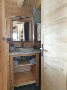 ein Bad mit einem Waschbecken und einem Spiegel in der Unterkunft BARMADZA Mazots de Charme in Demi-Quartier