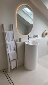 a bathroom with a sink and a mirror and a chair at Das Penthouse von Loftalive in Lollar