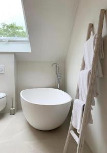 a white bath tub in a bathroom with a window at Das Penthouse von Loftalive in Lollar