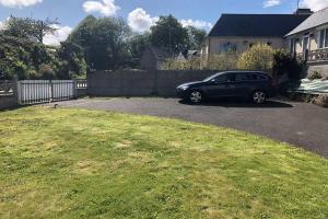 a black car parked in the driveway of a house at Charmante maison rénovée Proche plage,port,clos in Lézardrieux