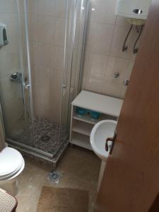 a bathroom with a shower and a toilet and a sink at Clock Tower Apartments in Podgorica