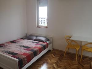 Un dormitorio con una cama y una mesa y sillas. en Clock Tower Apartments, en Podgorica