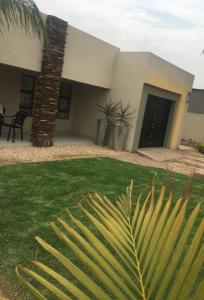 a house with a palm tree in front of it at Maso palace in Polokwane