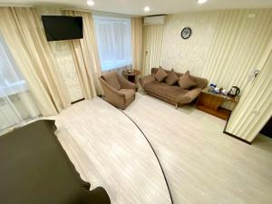 een woonkamer met een bank en een tv bij Cosmos Business-Hotel in Kurgan