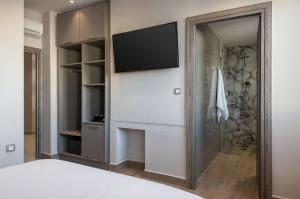 1 dormitorio con TV de pantalla plana en la pared en Al Daliani Minaret Rooms en La Canea