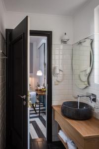 łazienka z umywalką i lustrem na ścianie w obiekcie Elia Portou Due w Chanii