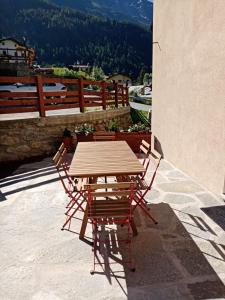 un tavolo in legno e sedie posti su un patio di Casa vacanza il Granaio a La Thuile