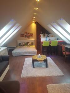 a attic living room with a bed and a table at Rodzinny ,Luksusowy Apartament nad jeziorem w centrum Mragowa in Mrągowo