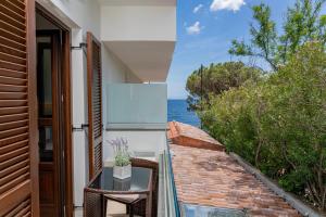 a balcony with a table and a view of the ocean at Hotel Ristorante La Conchiglia in Cala Gonone