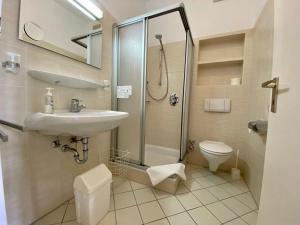 een badkamer met een wastafel, een douche en een toilet bij Adamidis Hotel in Altenmedingen