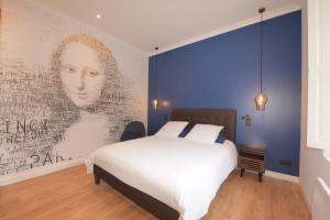 1 dormitorio con 1 cama y un gran mural en la pared en la maison du philosophe, en Amboise