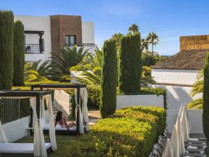 une femme assise sur une balançoire dans le jardin d'une maison dans l'établissement Hotel Fuerte El Rompido, à El Rompido