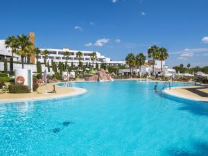 
a large swimming pool in a resort area at Hotel Fuerte El Rompido in El Rompido
