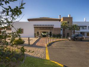 ein vor einem Gebäude geparkt in der Unterkunft Hotel Fuerte El Rompido in El Rompido