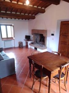 ein Wohnzimmer mit einem Holztisch und einem Kamin in der Unterkunft Agriturismo Naioli in Pitigliano