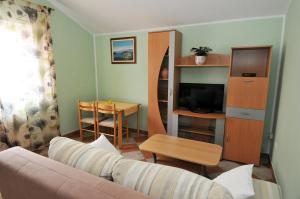 a living room with a couch and a table at Apartments Bugenvila in Cavtat