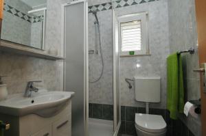 y baño con ducha, aseo y lavamanos. en Apartments Bugenvila, en Cavtat