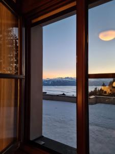 a window with a view of the mountains at Apartment Wanderlust Gerlitzen in Kanzelhöhe +14 photos
