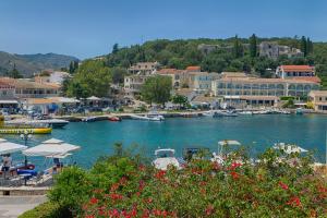 a harbor with boats in the water and buildings at MANESSIS Apartments Kassiopi Bay Corfu in Kassiopi