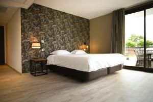 a bedroom with a large bed and a large window at Hôtel Les Muses in Annecy