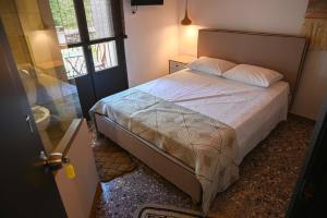 Schlafzimmer mit einem Bett und einer Glastür in der Unterkunft Elia’s Guest House in Koríni