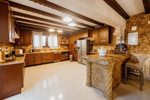 uma grande cozinha com armários de madeira e uma parede de pedra em Grand Mansion Countryhouse & Spa em Phrenaros