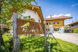 a sign in front of a building with a house at Pension Gimpl in Siegsdorf