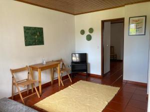 sala de estar con mesa y TV en Apartamentos Vale Da Varzea, en Areia Branca