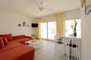 un soggiorno con un divano rosso e un tavolo di LEON INMO Apartment Bella - 10412 a Empuriabrava