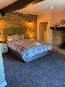 a bedroom with a bed and a stone wall at Bear Inn in Bisley