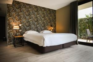 a bedroom with a large bed and a large window at Hôtel Les Muses in Annecy