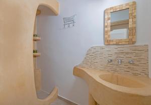 y baño con lavabo de madera y espejo. en Elia Traditional suites en Astipalea