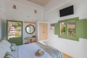 1 dormitorio con ventanas con persianas verdes y 1 cama en Elia Traditional suites en Astipalea