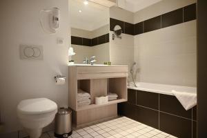 a bathroom with a toilet and a sink and a tub at Hôtel Les Muses in Annecy +37 photos