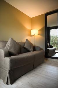 a living room with a couch and a mirror at Hôtel Les Muses in Annecy