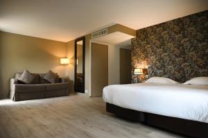 a hotel room with a large bed and a couch at Hôtel Les Muses in Annecy
