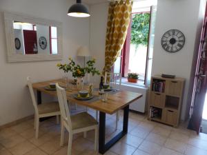 comedor con mesa de madera y sillas en Chez Jean - Newly renovated air-conditioned flat at the foot of the ramparts, 4 people, en Carcassonne