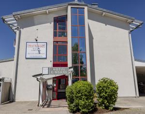 a building with a sign in front of it at Hotel KonradP Holzkirchen in Holzkirchen