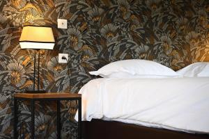 a bedroom with a bed with a floral wallpaper at Hôtel Les Muses in Annecy